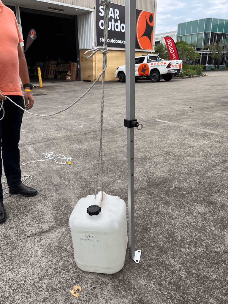 Water jugs tied to a marquee leg