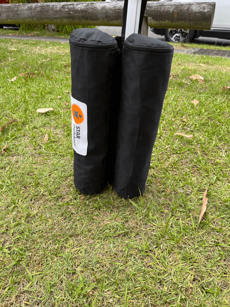 A sand-filled weight bag strapped to a marquee leg